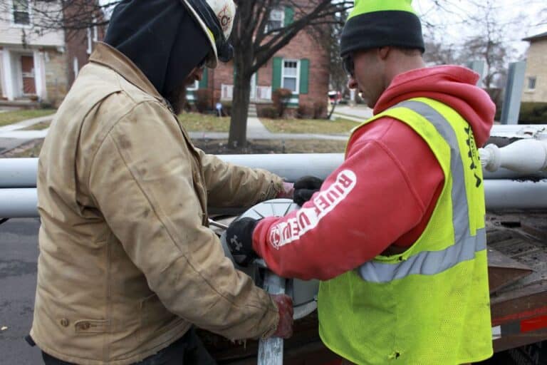 Sheldon-Cone-Jr-of-Clarkston-left-and-Jason-Catlett-of-Emmet-right-work-to-secure-an-old-street-light-to-a-truck-on-December-17-2014-in-the-Sherwood-Forest-neighborhood-in-Detroit